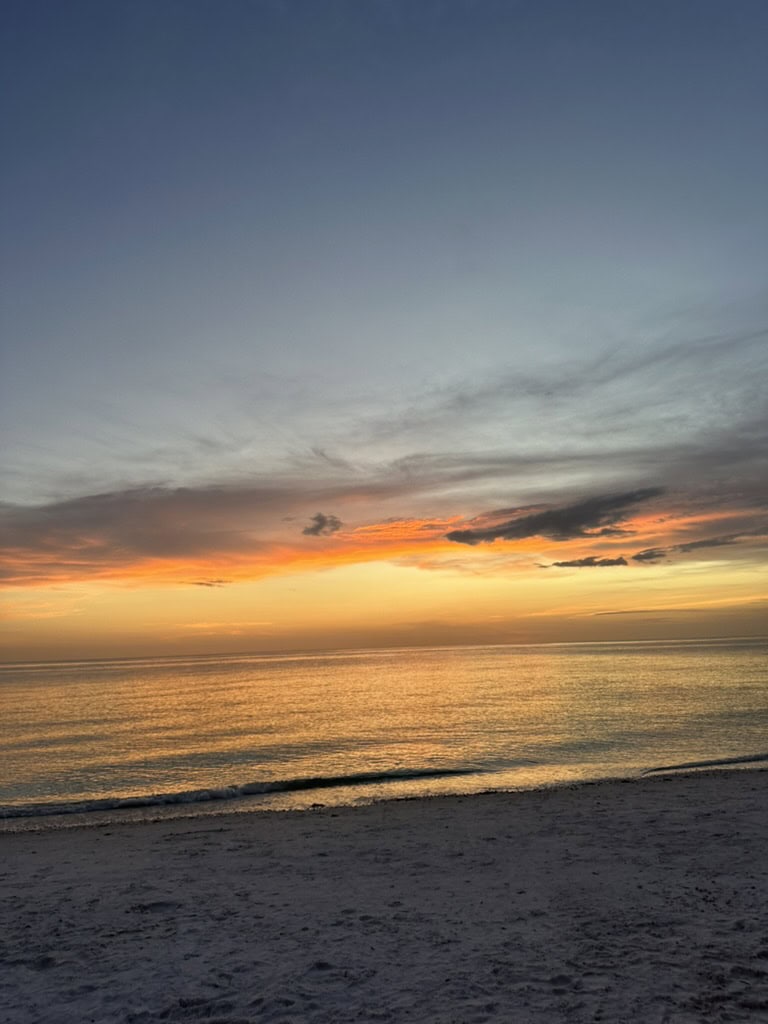 Soft orange dusk sky over a quiet Gulf beach and gentle shoreline, Marco Island, Florida