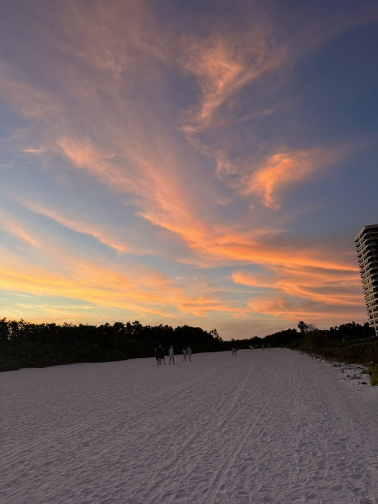 Pink evening clouds stretching over a wide sandy Gulf beach at dusk, Marco Island, Florida