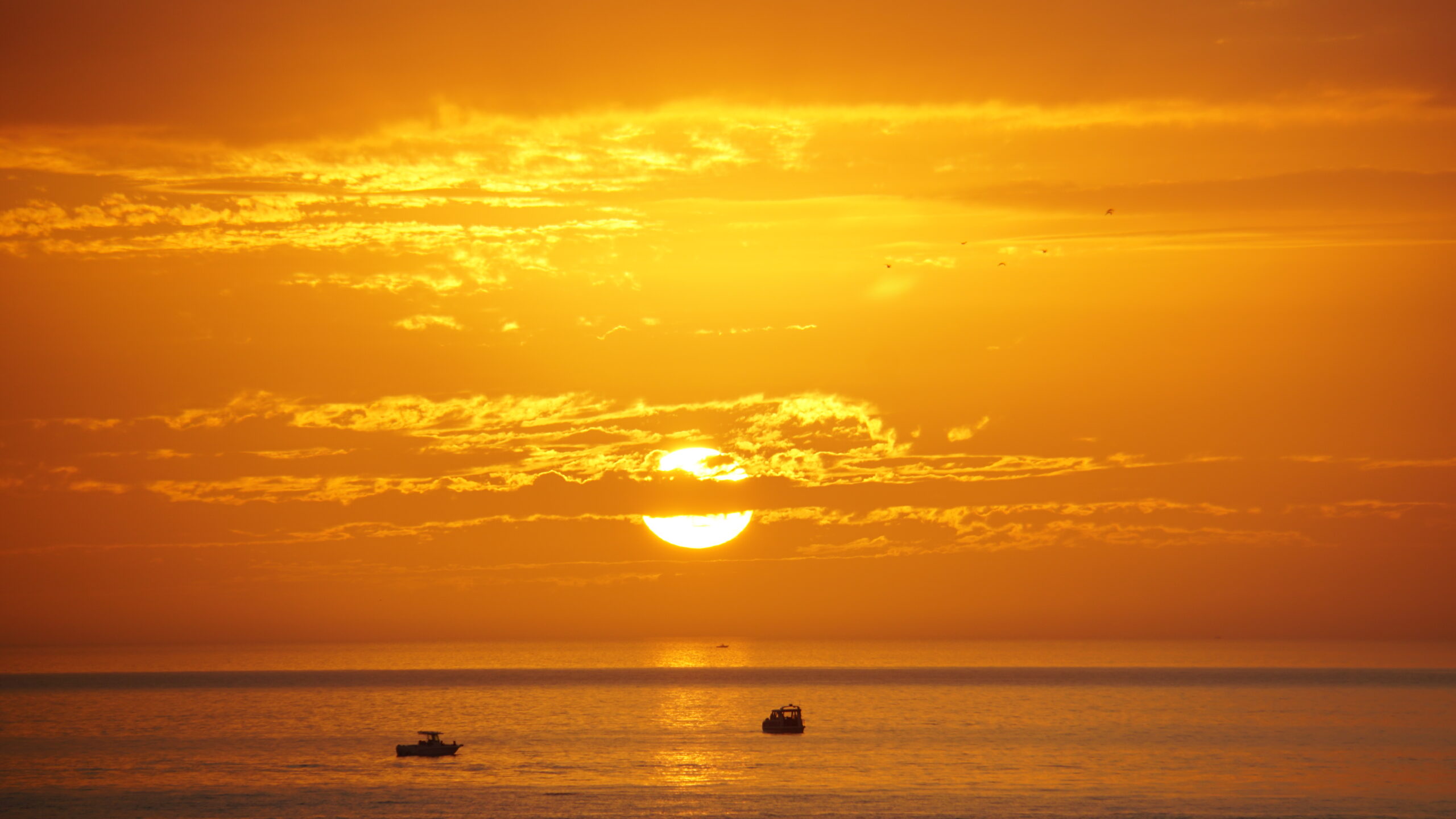 Golden sunset reflection over the Gulf with small boats on the horizon, Marco Island, Florida