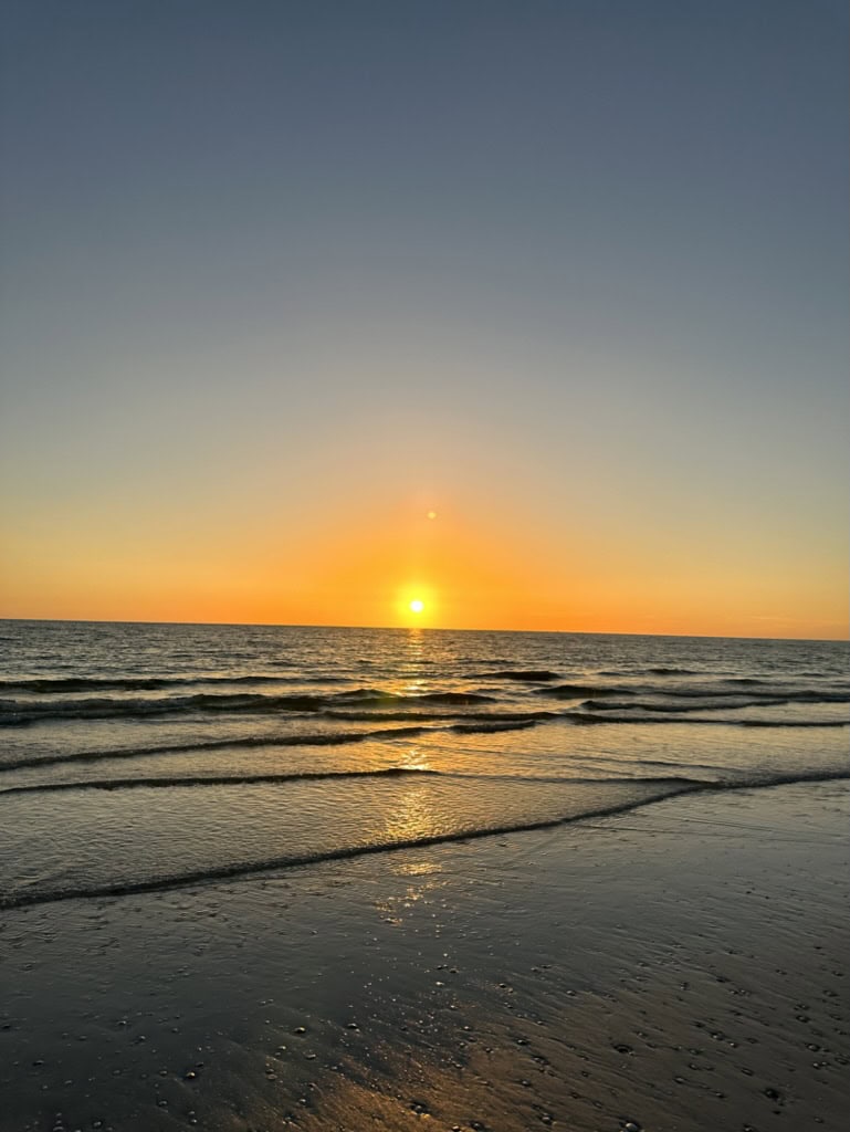 Bright sunset reflecting across wet sand and small Gulf shore break, Marco Island, Florida